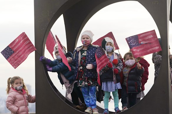 Children from the Children's Workshop, an arts and science preschool, pause in a sculpture with flags they made in celebration of the inaugurations of President Joe Biden and Vice President Kamala Harris Wednesday, Jan. 20, 2021, in Seattle.