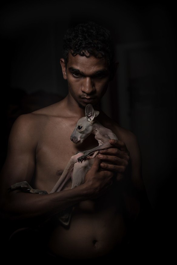 Landon Punch with an orphaned baby kangaroo. Landon killed the baby kangaroo's mother for food and will now hand-rear the joey until it is big enough to survive in the wild.