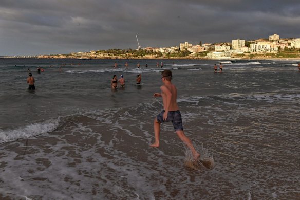 Locals race to the water at Bondi beach. 