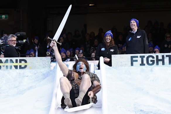 David Neitz, former Melbourne great, goes down the slide for Big FightMND Freeze 8, during the round 13 AFL match between the Collingwood Magpies and the Melbourne Demons at Melbourne Cricket Ground on June 13, 2022 in Melbourne, Australia.
