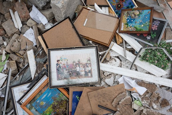 A damaged frame with a photo of children lies in the bombed-out wreckage of Barvinok kindergarten in Makariv.