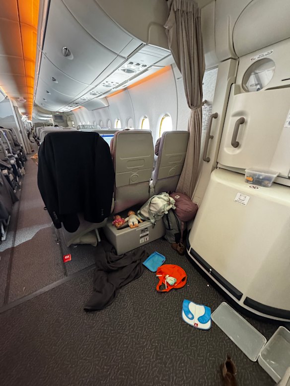 The space around the exit is turned into a makeshift creche by some parents during the flight.