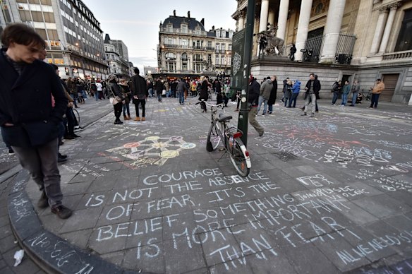 People write hundreds of messages on the asphalt at Place de la Bourse in the center of Brussels to mourn for the victims of todays attack.