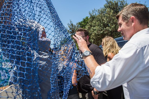 A protester attempts to net Premier Mike Baird in Ballina after the installment of the first shark net on the north coast.