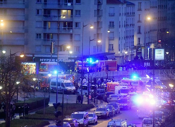 French firemen and emergency doctors enter a kosher deli during a hostage situation at Port de Vincennes.