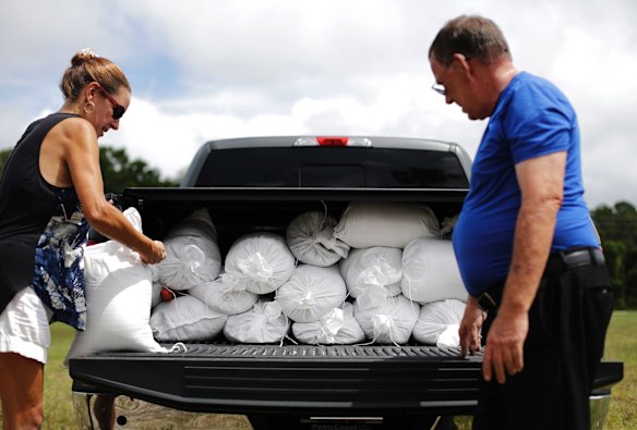 Jackie Cullen helps Bob Boos load sandbags into his truck at a makeshift filling station provided by the county as protection ahead of Hurricane Irma in Palm Coast, Florida.