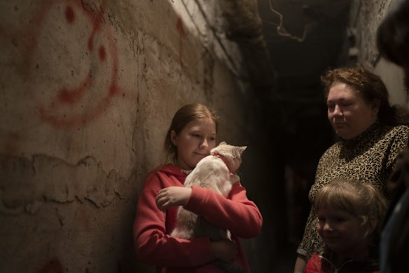 Elizabeth, 12, holds her cat as she takes shelter with her family inside the basement of a residential building during a Russian attack in Lyman.