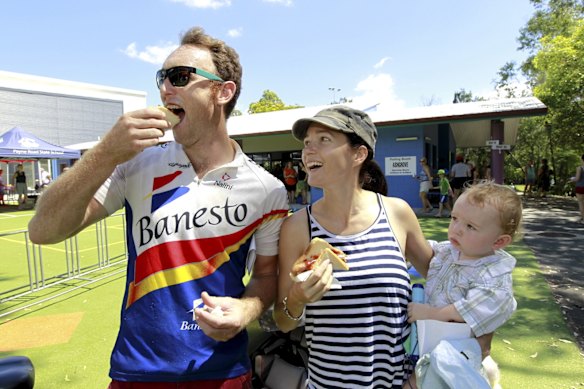 Ed Annand, Holly High and baby Gadsby Annand enjoy a sausage at The Gap State School on election day.
