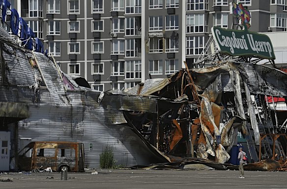 A man is dwarfed by the ruins of a building impacted by Russian shelling and missiles in Bucha.