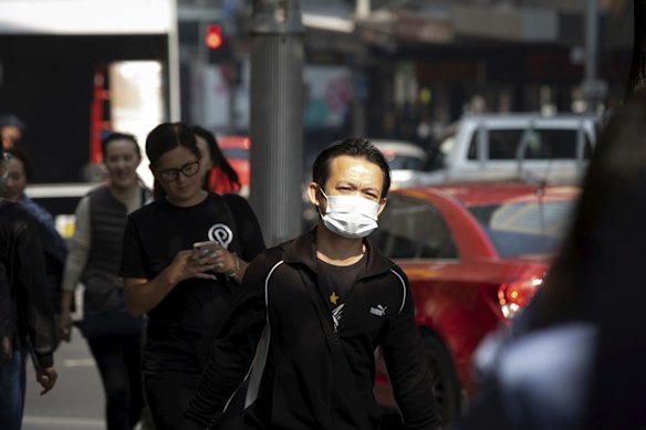 People wear masks in Sydney due to the smoke haze from the bushfires. 