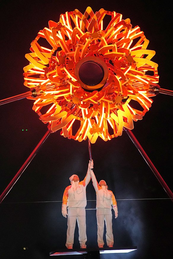 Italian former skier Deborah Compagnoni and Italian former skier Alberto Tomba light the cauldron at the Arco della Pace during the Olympic opening ceremony at the 2026 Winter Olympics.