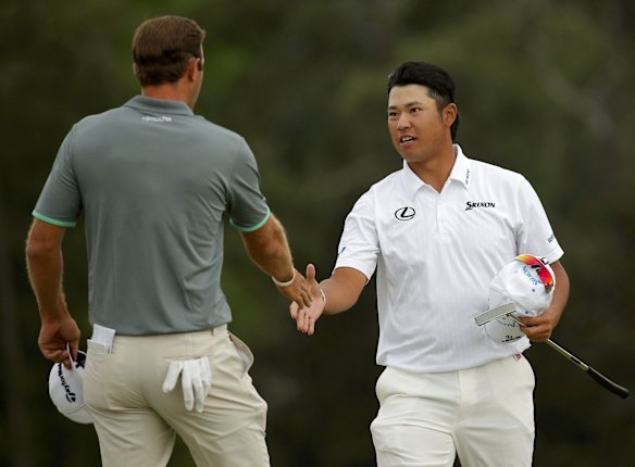 Hideki Matsuyama of Japan (R) shakes hands with Dustin Johnson of the US after they finished on the 18th green.