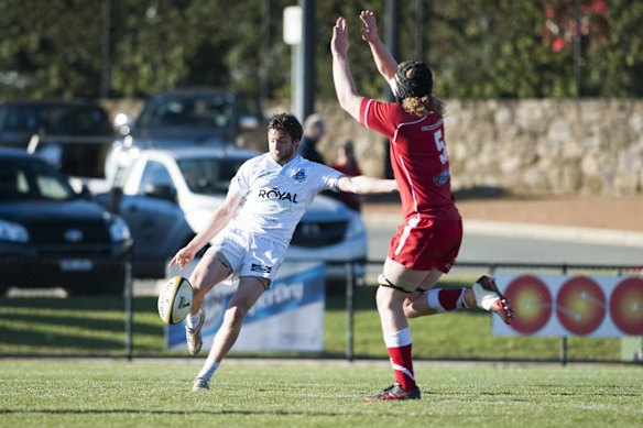 Queanbeyan's Zac Tarrant kicks the ball and Vikings 'Callum Smith tries to run it down.