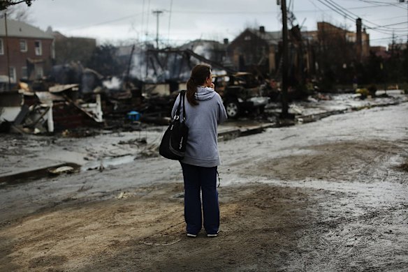 A woman stands near destroyed homes after Hurricane Sandy on October 30, 2012 in the Rockaway section of the Queens borough of New York City.