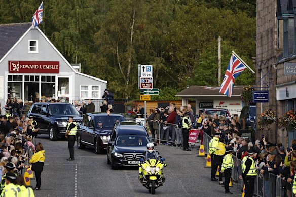 BALLATER, ABERDEENSHIRE - SEPTEMBER 11: People gather in tribute as the cortege carrying the coffin of the late Queen Elizabeth II passes by on September 11, 2022 in Ballater, United Kingdom. Elizabeth Alexandra Mary Windsor was born in Bruton Street, Mayfair, London on 21 April 1926. She married Prince Philip in 1947 and ascended the throne of the United Kingdom and Commonwealth on 6 February 1952 after the death of her Father, King George VI. Queen Elizabeth II died at Balmoral Castle in Scotland on September 8, 2022, and is succeeded by her eldest son, King Charles III. (Photo by Jeff J Mitchell/Getty Images)