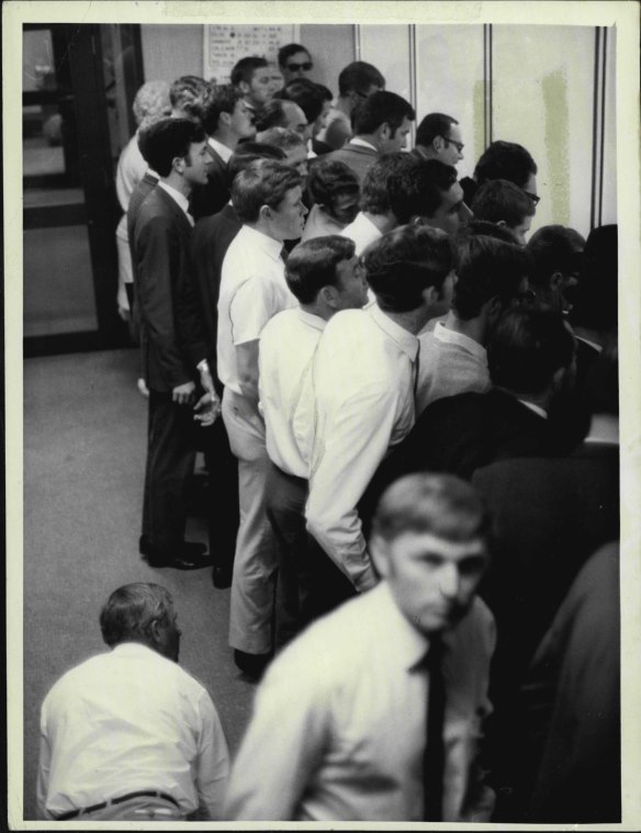 An investor is down on his hands and knees, peering between legs to get a look at the boards on the Perth Stock Exchange. This was the scene in the public gallery at Exchange House morning's call. October 23, 1969, at the height of the Poseidon nickel boom.