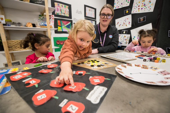Goodstart Flinders Street director Chelsea Snowden plays a counting game with children Angelique, Mila and Lara. 