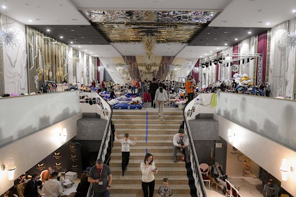 Refugees who fled the Russian invasion from neighbouring Ukraine sit inside a ballroom converted into a makeshift refugee shelter at a four-star hotel in Suceava, Romania. The hotel is about 50km from the border with Ukraine. Wedding parties and conferences have been cancelled.
