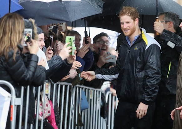 Prince Harry meets members of the public during a walkabout in the torrential rain ahead of a Sydney 2018 Invictus Games Launch Event at the Overseas Passenger Terminal on June 7, 2017 in Sydney, Australia.