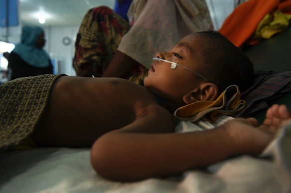 Jomil aged 2 lays unconscious whilst being treated for fever and breathing problems.