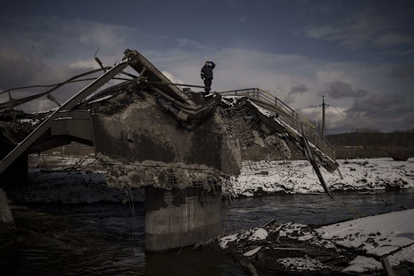 A man stands atop a destroyed bridge in Irpin, on the outskirts of Kyiv, Ukraine.