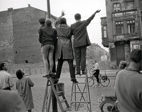 West Berliners look across the Berlin Wall to the east in 1961. 
