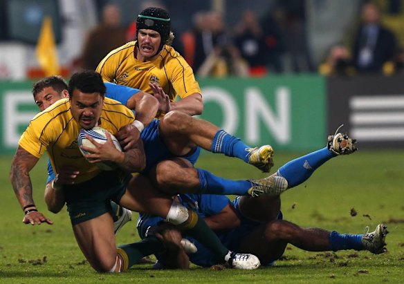 Australia's Digby Ioane  is tackled by Italy's Luke McLean .