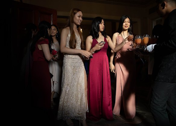 Grace Au, Tiffany Fung and Jade He accept non-alcoholic mocktails at their school formal at Curzon Hall.