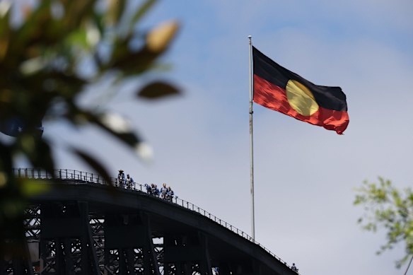 The Australian Aboriginal Flag flies atop the Sydney Harbour Bridge on Australia Day: the first time since the federal government announced it had paid more than $20 million to Luritja artist Harold Thomas and licence holders to secure copyright for the iconic flag.