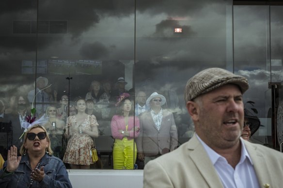 Racegoers brave the rain while others stay dry at the 2022 Melbourne Cup at Flemington Racecourse.