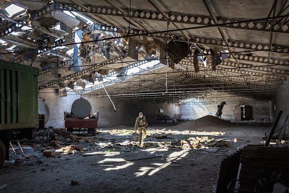 A Ukrainian army officer inspects a grain warehouse earlier shelled by Russian forces, near the frontlines of Kherson Oblast in Novovorontsovka. Russia has been accused of targeting food storage sites in frontline areas and generally degrading Ukraine's wheat production, potentially causing a global shortage.