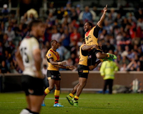 Triumph: Justin Olam celebrates his try for the Kumuls against Fiji.