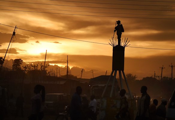 People walk past one of the many statues of a man with arrows that were erected about Juba during the civil war as a warning from the Bari tribe to other tribes that this is their territory.