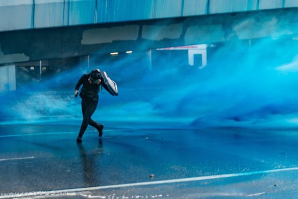 Pro-democracy protesters react as police fire water cannons at them outside the Central Government Complex on September 15, 2019 in Hong Kong, China. 