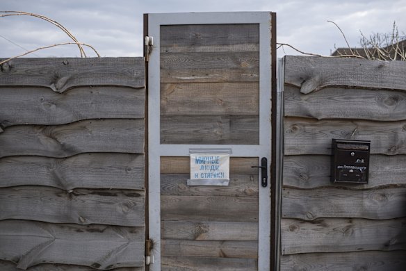 A sign on a door in Bucha says "Peaceful people and the elderly".