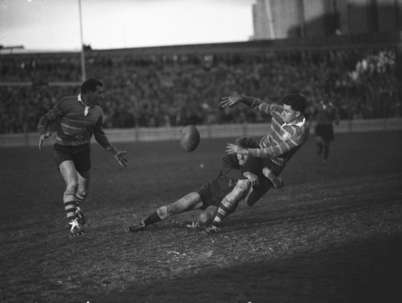 “Encircling gloom...”  A Country player tackles a City player in the final minutes of the match.