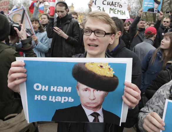 Demonstrators carry posters depicting Russian President Vladimir Putin during a massive protest rally in St.Petersburg.
