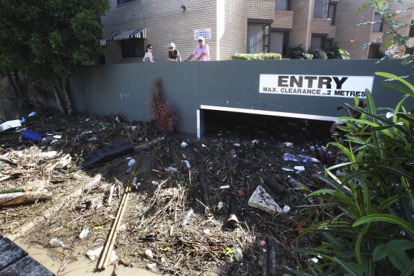 Ross and Ronnie Girdham look at the garbage and debris surrounding their riverside units in Toowong.