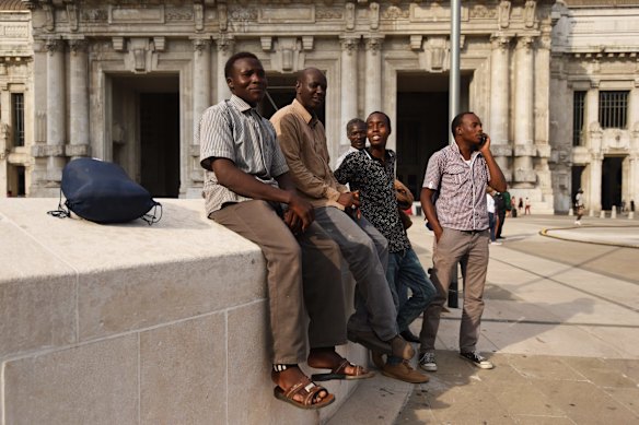 Refugees from Darfur in Sudan Idris Ahmed 25 (left), Haitham Adam 30 (2nd from left), Adel Ahmed 18 (2nd from right) and Mohamaed Ahmed 23 (right) in front of the Milan Central Station after buying their tickets to France.