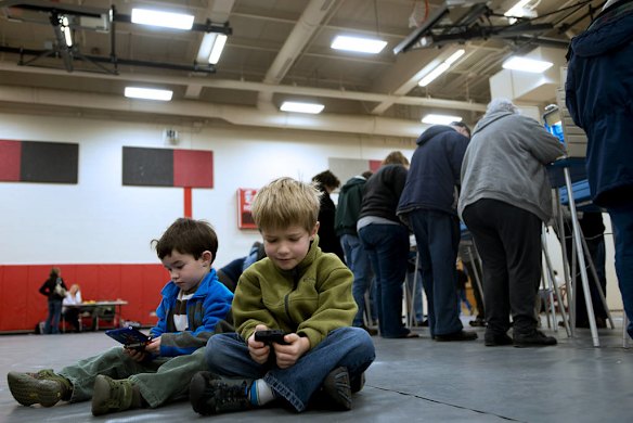 Miles Burkett and his brother Sullivan play games on consoles while their parents to cast ballots in Ohio on election Day 2012