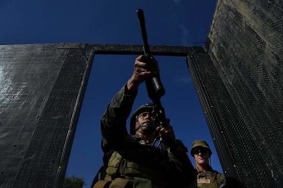 Private Brodie Smith (right) with the 8th/9th Royal Australian Regiment and Land Mobile Training Team observes a Filipino marine as he enters a mock building during urban combat training.