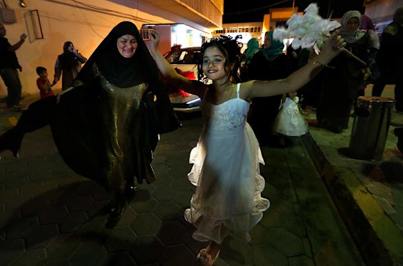 Female relatives dance infront of the bridal car in celebration as they arrive at the Baghdad Hotel in the Al-Sadoon area of Baghdad, where the bridal couple will spend their wedding night. Twenty two weddings arrived at the Baghdad Hotel for the evening.