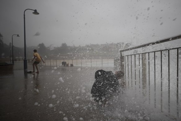 Wild weather at Bronte as a swimmer tries to enter the ocean pool.