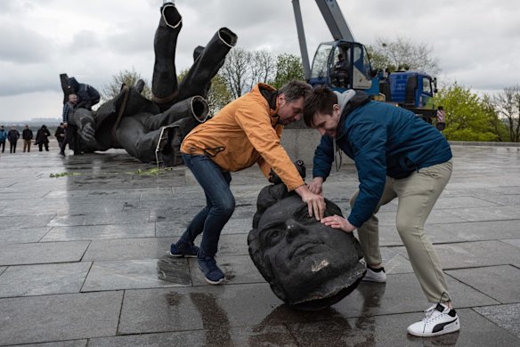 Two men move a head from the The 'Friendship of Peoples' monument during its demolition in Kyiv. Kyiv's Mayor Vitali Klitschko announced in a social media post that the 8-meter high statue of men holding a star-shaped emblem that says "Friendship of Peoples" and "USSR" would be removed from the city, and the metal arch overhead would be renamed.