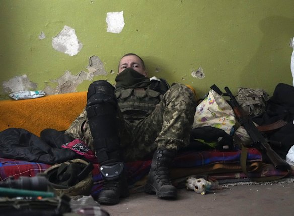 A Ukrainian soldier rests in a basement for shelter in the center of the town of Irpin, northwest of Kyiv.