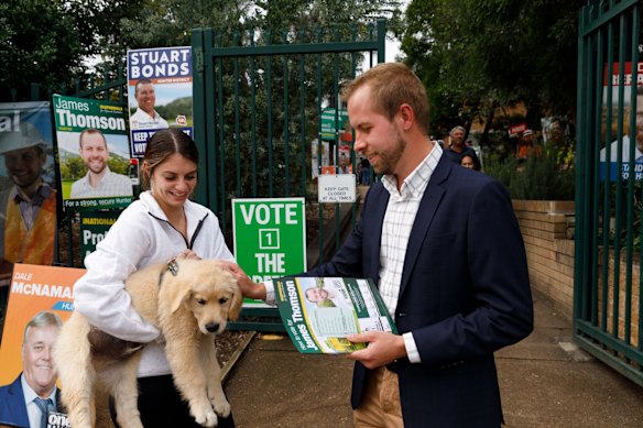 Nationals cadidate James Thomson meets Simone Merrick and her puppy Maverick outside Singleton Heights polling centre in the upper Hunter Valley town of Singleton.