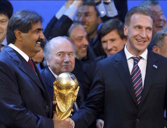 Qatar's Emir Sheikh Hamad bin Khalifa al Thani and Russia's Deputy Prime Minister Igor Shuvalov celebrate as FIFA President Sepp Blatter looks on.