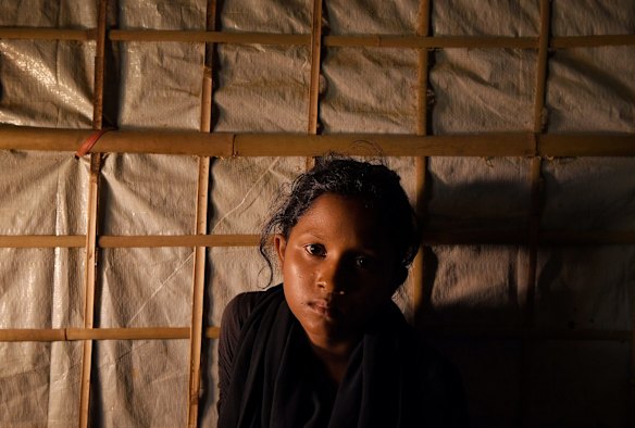 Rohingya refugee Yasmin Akhter aged 13 sits in the shelter she shares with her foster father Zafar Alam and his family.