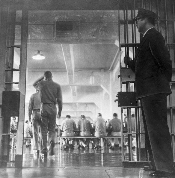 A guard stands by as prisoners enter the Alcatraz mess hall for supper in its days as a working prison.