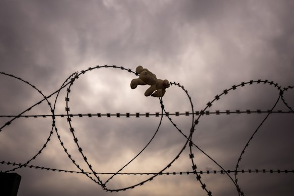 A cuddly toy doll is seen hooked on a barbed wire fence separating Ukraine and Poland at the Medyka border crossing in Poland.